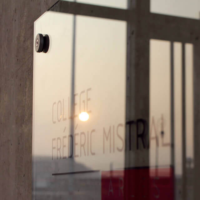 Plaque signalétique glasskit marcal fixée par entretoise sur mur béton